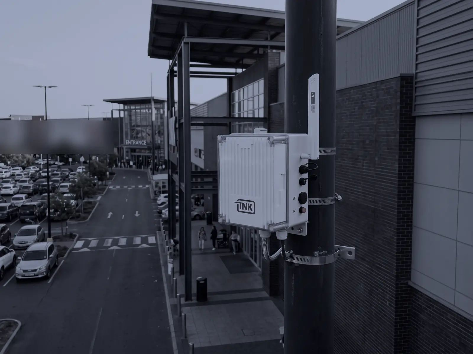 Sensor fijo de CarDefense en un poste junto a la entrada de un mall, sobre el estacionamiento